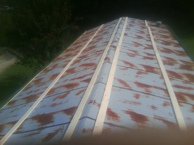 Rusted metal roof panels with new wood purlins before replacement — Storm Damage Roof Repair in Nickelsville by Roofing Brothers