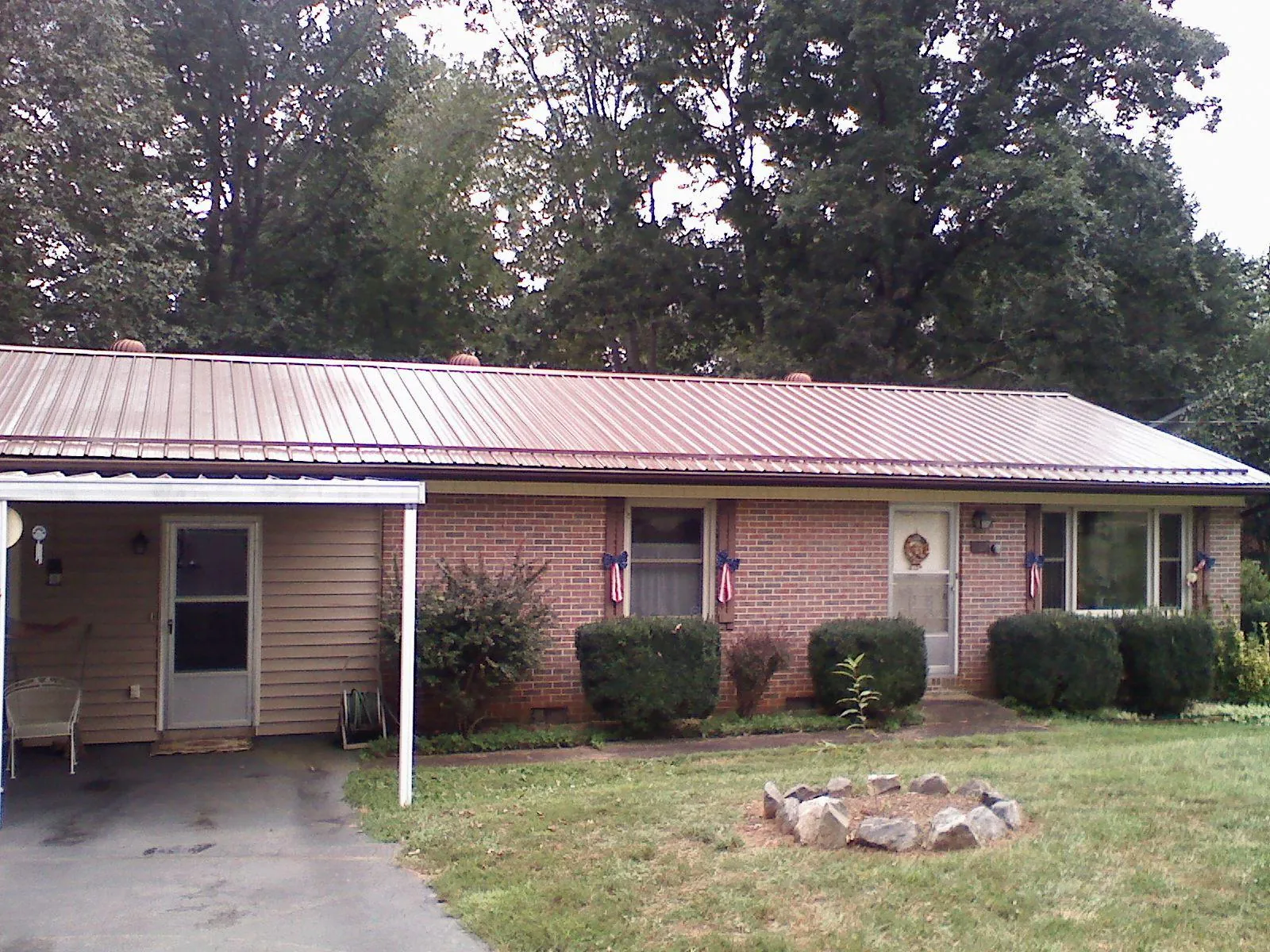 Bronze metal roof and carport on a brick ranch home — Roof Repair work by our crew in Nickelsville
